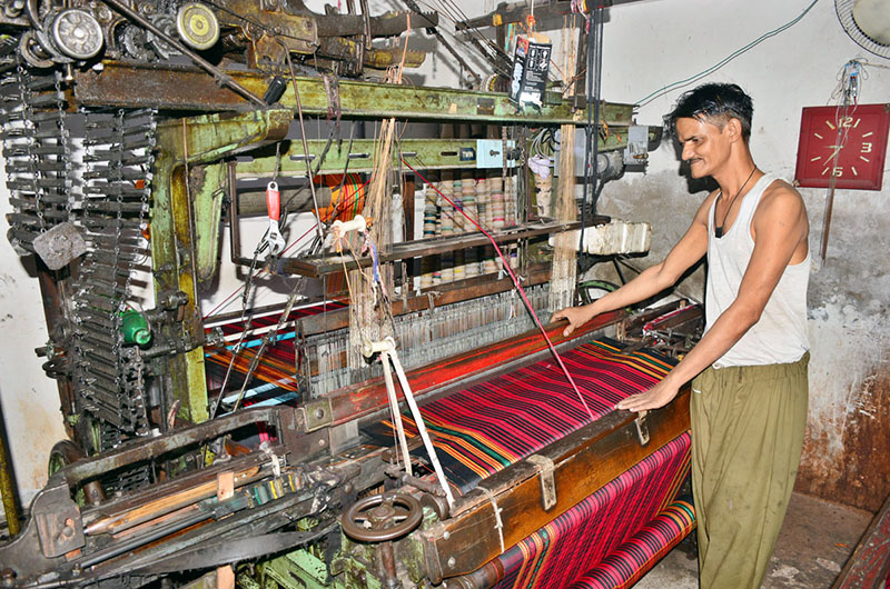 A worker preparing cloth on power loom in a local factory as International Labour Day is celebrated on May 1 every year. It's a day to honour and appreciate the contributions of workers all around the world. This day recognizes the hard work and dedication of people who work in various fields to make our lives better.