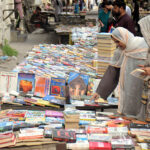 Women selecting old books from a roadside at Mall Road
