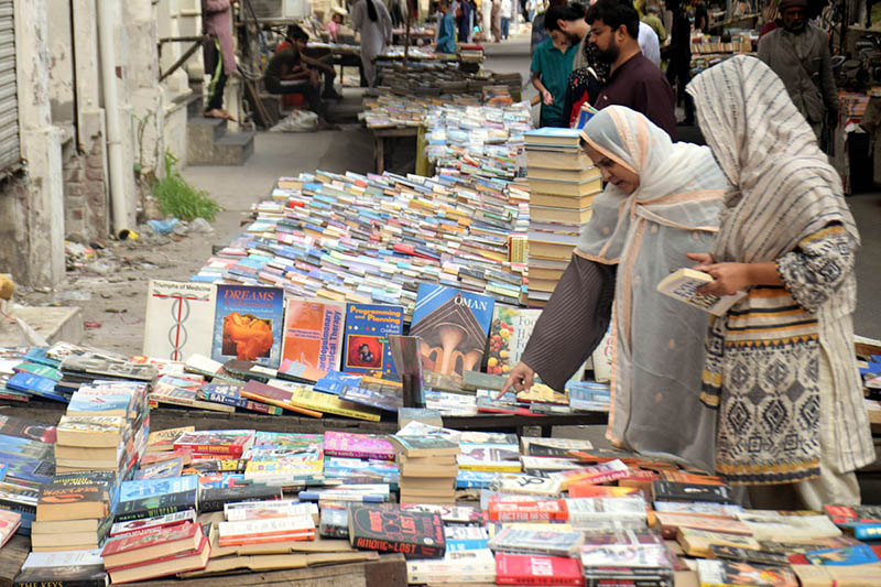 Women selecting old books from a roadside at Mall Road