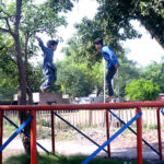 Children enjoying jumping on trampoline at vendors’ roadside setup