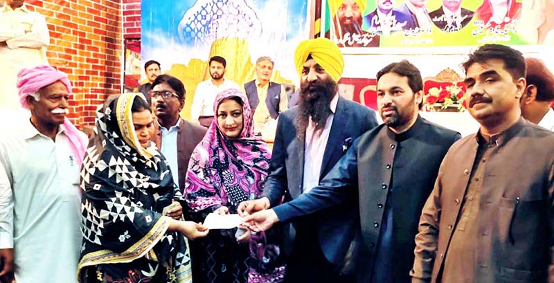 Provincial Minister Minority Affairs Sardar Ramesh Singh Arora and Deputy Speaker Punjab Assembly Malik Zaheer Iqbal Chand is distributing relief checks to minority women in a ceremony organized on the occasion of Easter and Holi