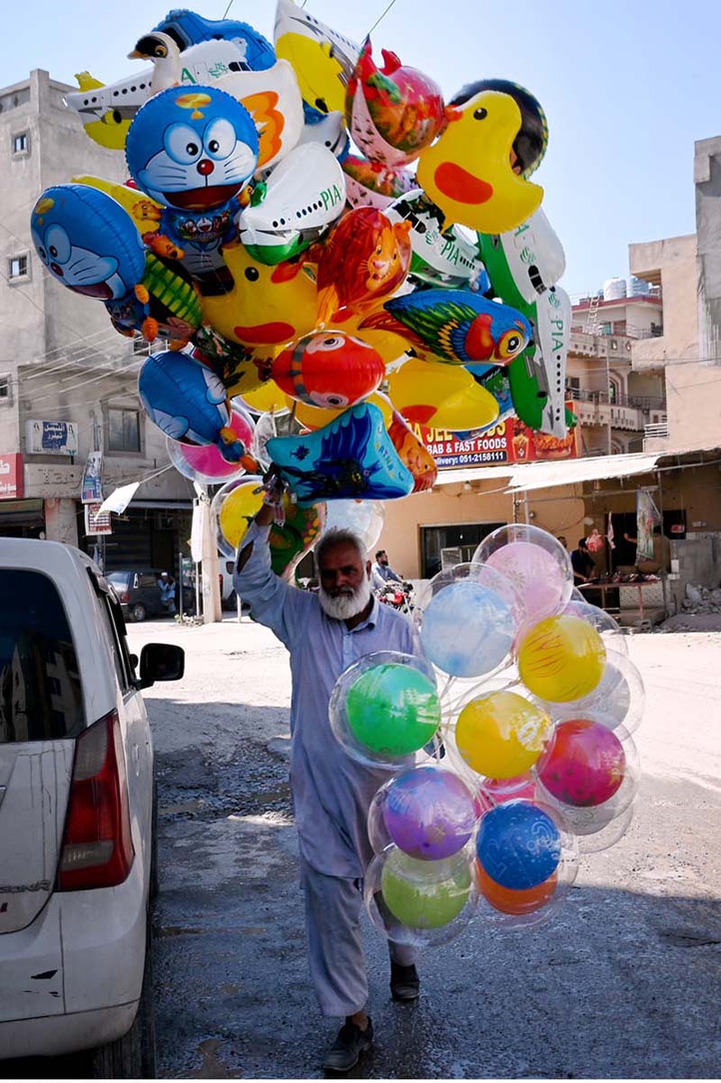 Elderly vendor selling colorful balloons while shuttling on the road