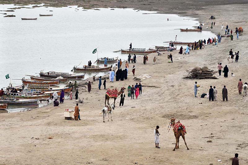 A large number of people arrive at the bank of Indus River to enjoy the cloudy weather.