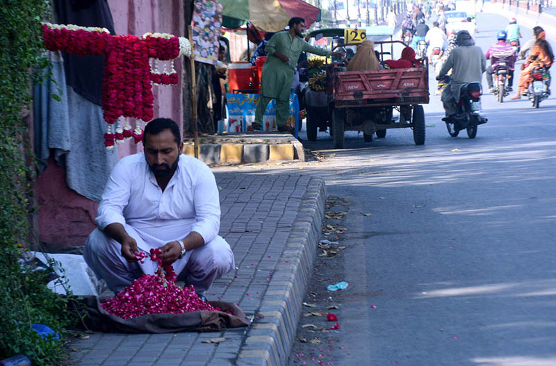 Vendor preparing garlands to attract customers at roadside