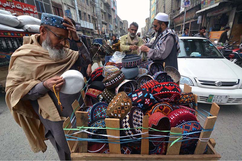 Vendor displaying prayer caps to attract the customers on his handcart.