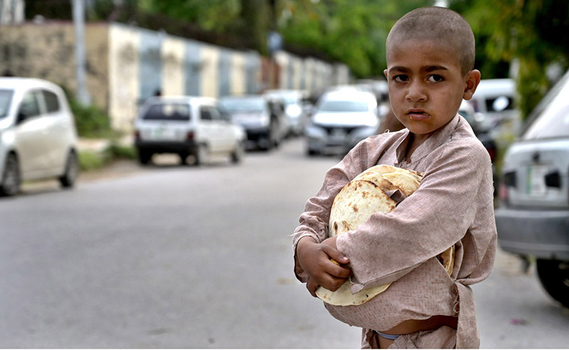 A gypsy youngster on the way while carrying bread (roti) which distributed by volunteer.