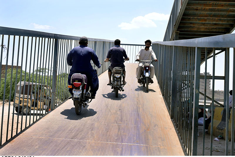 Motorcyclists crossing the Bypass Road through bridge.