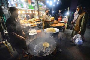 Vendor preparing traditional food item Tikkay for customers at Fawara Chowk during Ramadan.