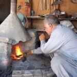 A blacksmith busy in making saw in traditional way on his work place at River view road