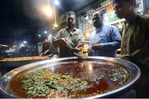 Vendor preparing traditional food item Tikkay for customers at Fawara Chowk during Ramadan.