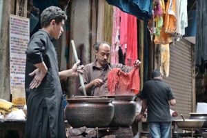 A vendor dying colour to Dupattain at his shop at Old Fort in Raja Bazaar.