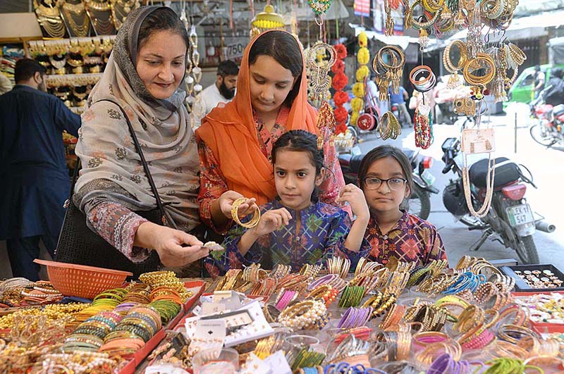 Women with children purchasing artificial jewelry during Eid shopping in preparation of upcoming Eid-ul-Fitr
