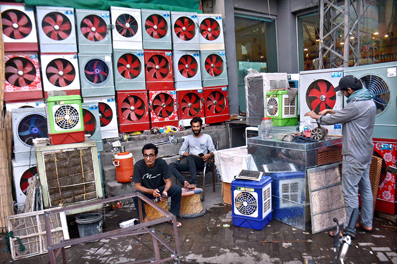 A worker is preparing room coolers at his workplace as per increasing demand in summer season