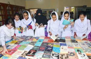 Students purchasing artificial jewelry from stall during Eid Festival at Shah Latif Girl College.