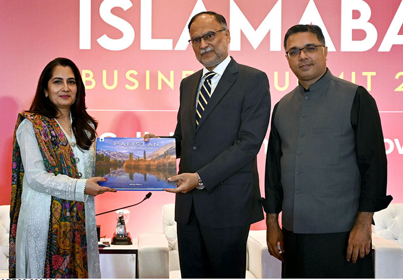 Federal Minister for Planning, Development & Special Initiatives Prof. Ahsan Iqbal giving away books among the participants during Leaders in Islamabad Business Summit 2024 collaborating for Growth.
