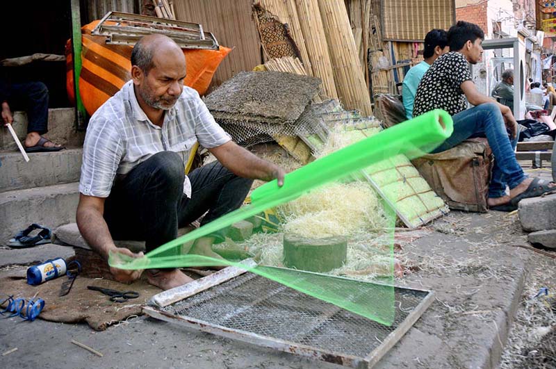 A street vendor making room cooler net at roadside