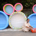 A vendor selling inflatable toys at his roadside setup