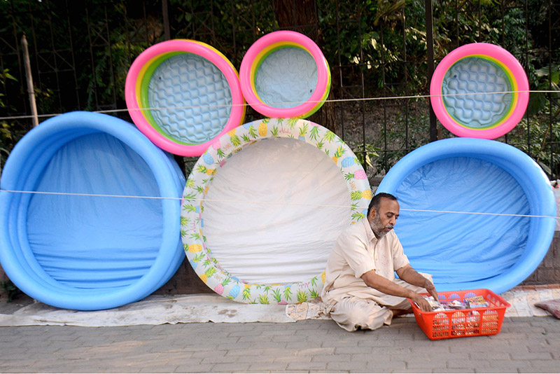 A vendor selling inflatable toys at his roadside setup