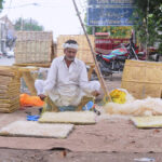 A worker preparing khas for the air cooler at his workplace