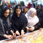 Women purchasing artificial jewelry ahead of Eid-ul-Fitr at Hyderi Market