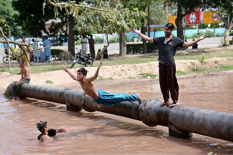 Youngsters diving in canal for swimming to get relief in hot weather in city