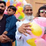Children purchasing balloons from a vendor outside Eidgah on the occasion of Eidul Fitr