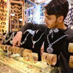 Vendor arranging and displaying artificial jewelry to attract the customers at Shafi Bazar