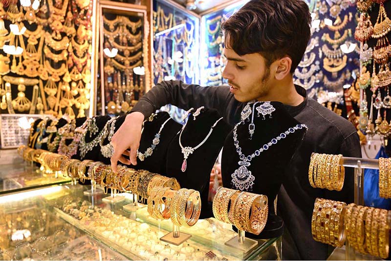 Vendor arranging and displaying artificial jewelry to attract the customers at Shafi Bazar