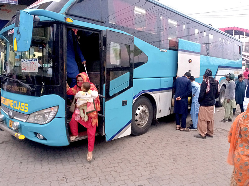 Families arriving back from their home town after Eid-ul-Fitr celebrations at Fiazabad Bus Stand.