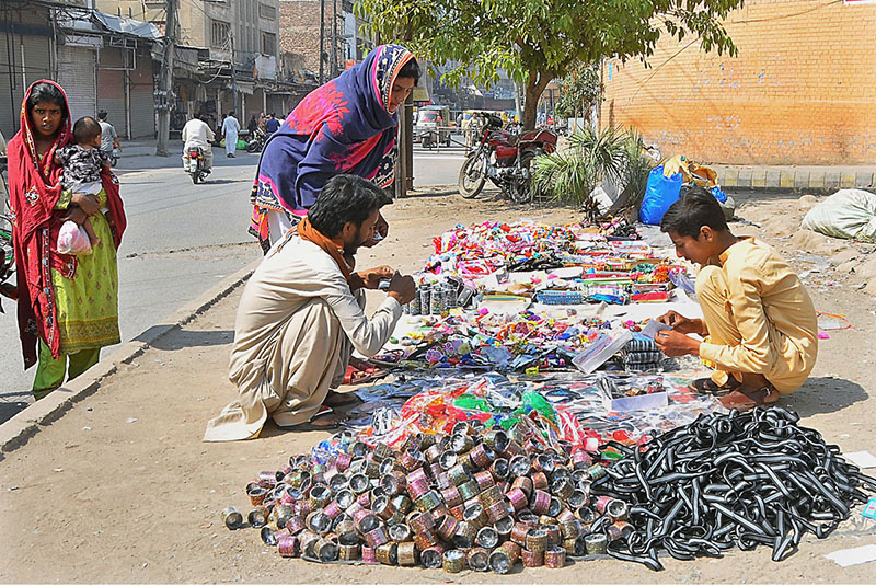 A vendor displaying bangles and other stuff to attract customers at roadside setup.