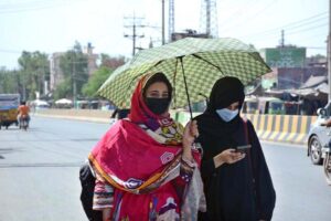 Students on the way under an umbrella to protect themselves from direct sunlight during hot weather.