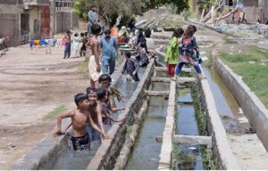 Youngsters bathing from leakage water supply pipeline to get relief from hot weather in the city at Chenal mori canal.