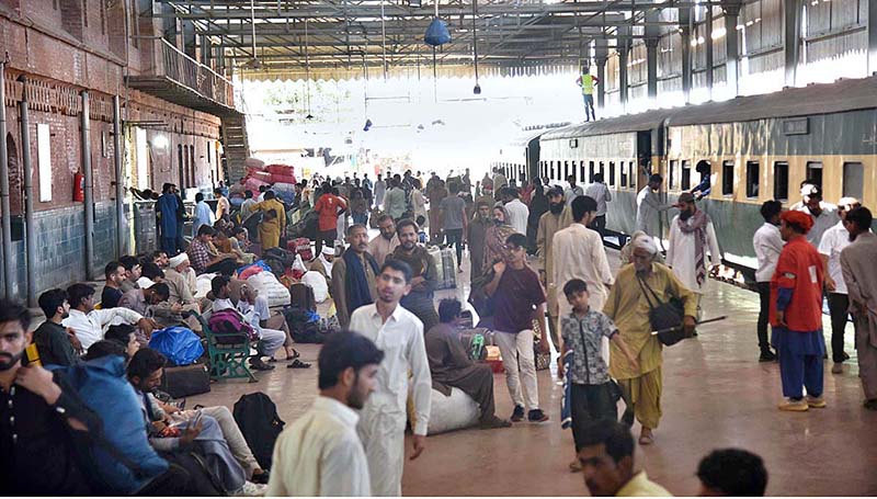 People along with their luggage arrives at Railway Station to leave for their hometowns to celebrate Eid-ul-Fitr with their loved ones