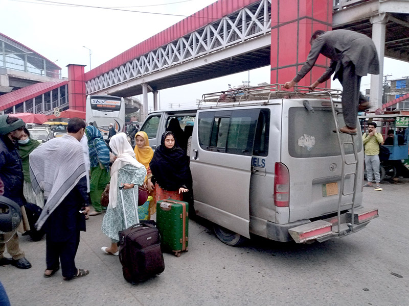 Families arriving back from their home town after Eid-ul-Fitr celebrations at Fiazabad Bus Stand.
