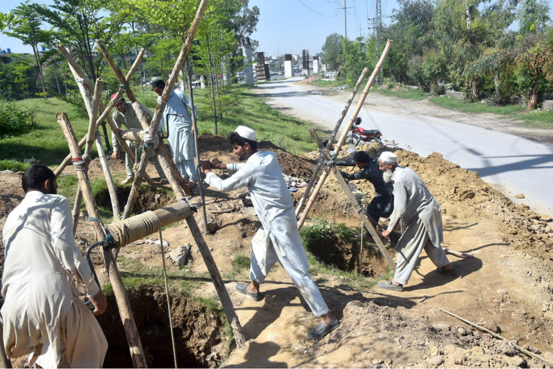 Laborers work tirelessly to dig for the construction of WAPDA Pole Fitting along IJP Road.
