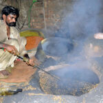 worker busy in roasting grams at his workplace.