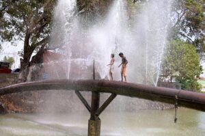 Youngsters bathing from leakage water supply pipeline to get relief from hot weather in the city at Chenal mori canal.