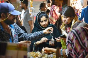 Women selecting and purchasing children sandals in preparation of Eid-ul-Fitr