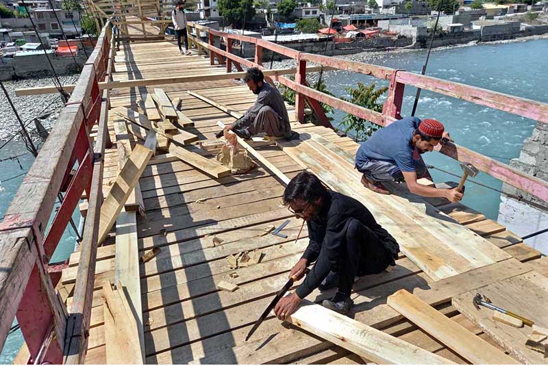 Workers busy in repairing work of the historical 100 years old suspension wooden bridge Kunodas.