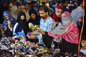 Women selecting and purchasing children sandals in preparation of Eid-ul-Fitr
