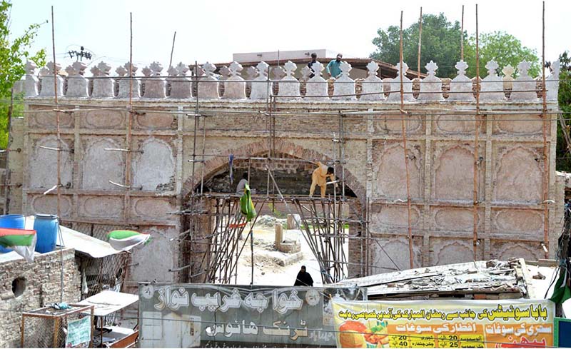 Labourers repair the Pukka Fort entrance gate at Pukka Fort Chowk.