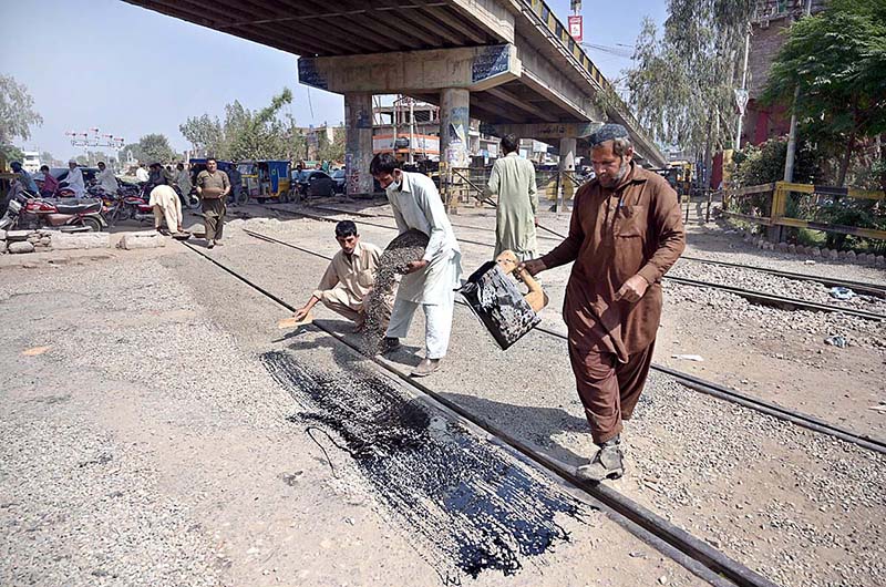 Railway workers are busy in repairing railway track near Railway station phatak.