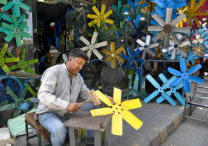A worker busy in preparing air cooler fans at his workplace.