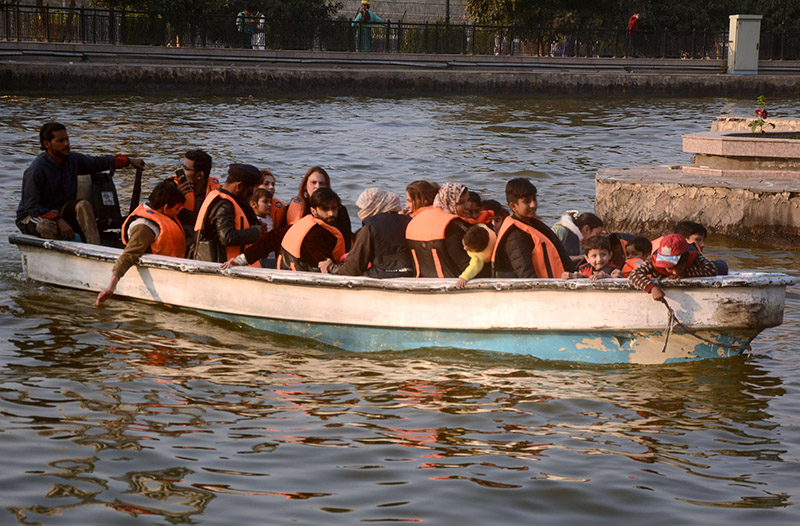 Visitors enjoy boat ride in Greater Iqbal Park at evening time