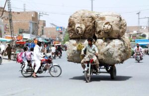 Motorcycle loaded with items collected from garbage heaps is on way to its destination.