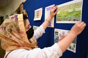 SBBWU students displaying Eco friendly practices and sustainable climate change initiatives charts on a wall during their visit at Trans Peshawar Headquarter.