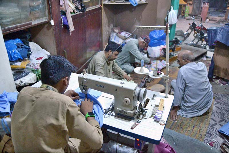 Tailors are busy in stitching clothes at their workplace in Islampura as per increased demand of customers in preparation of upcoming Eid Al-Fitr.