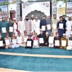 A group photograph of guests of honor with students who have memorized the Holy Quran at Dara ul Aloom Noor ul Quran