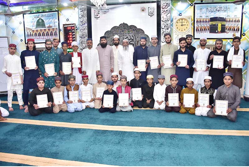 A group photograph of guests of honor with students who have memorized the Holy Quran at Dara ul Aloom Noor ul Quran