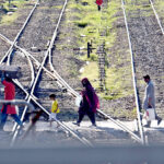 Passengers carry their luggage as they arrive at the railway station to depart for their hometowns to celebrate the Eid al-Fitr with their loved ones